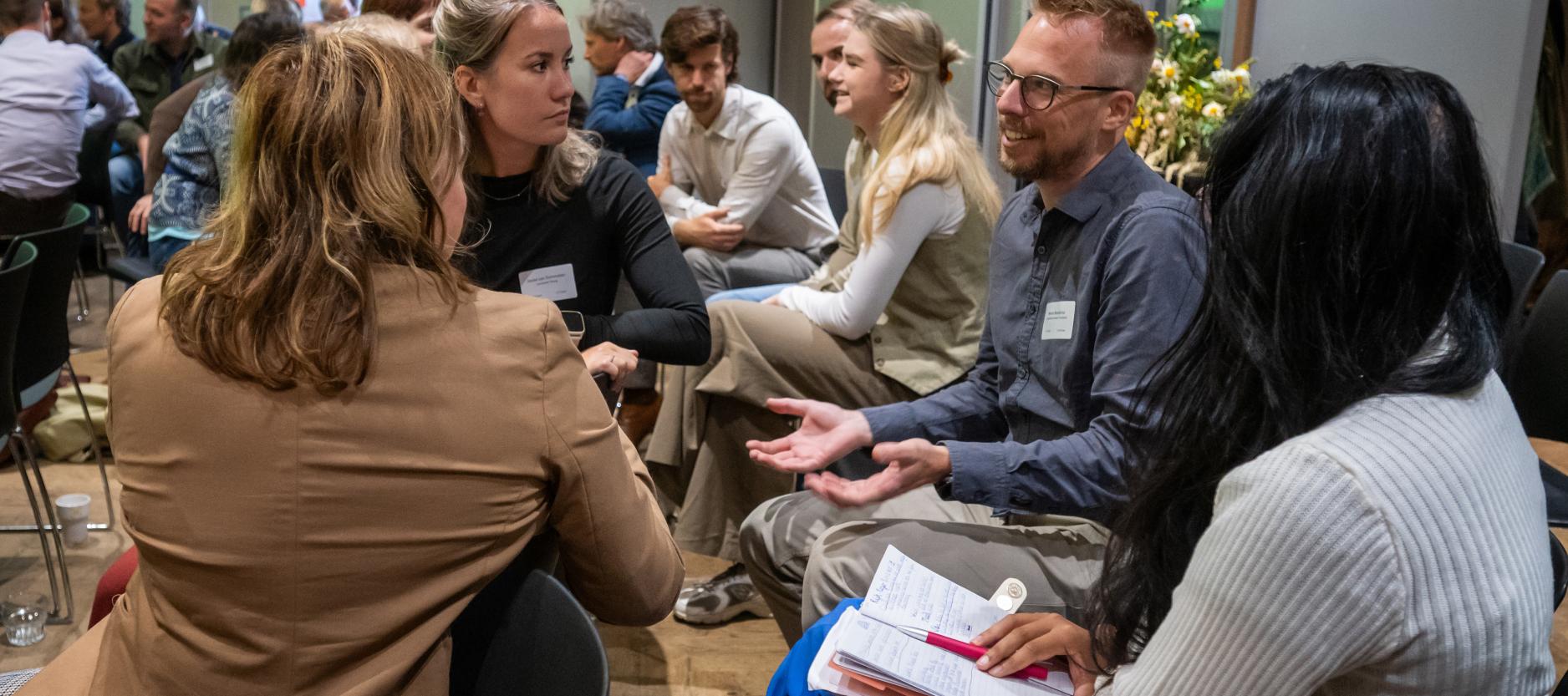 Groepje mensen met elkaar in gesprek tijdens een congres.