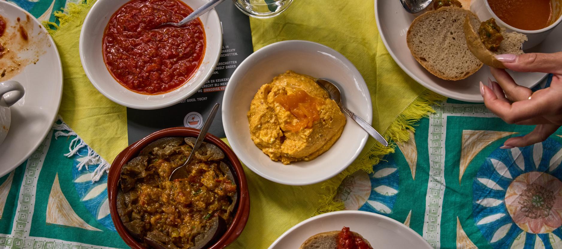 Een tafel met daarop een paar schaaltjes met dips gemaakt van geredde groenten.